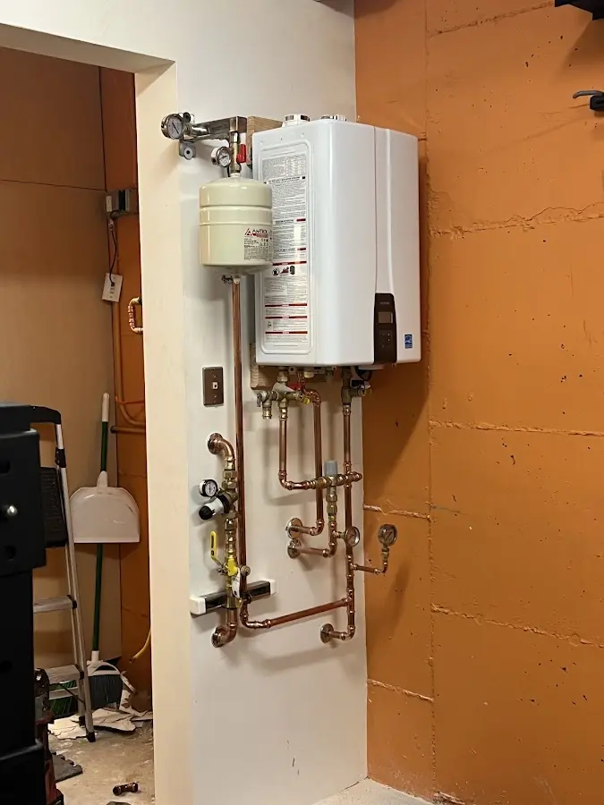 Plumbing technician inspecting water heater connections in Newberry